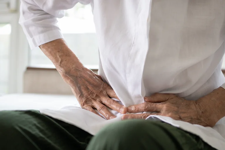 Mann greift sich mit Händen in den Unterbauch. Da die Symptome der chronischen Pankreatitis recht unspezifisch sind und auf verschiedene Krankheiten hinweisen könnten, vergeht häufig eine längere Zeit bis zur richtigen Diagnosestellung.