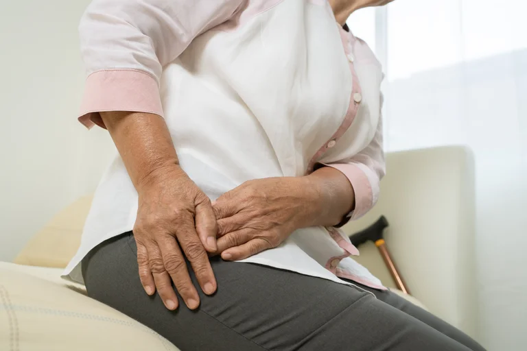 Ältere Frau mit Coxarthrose hat Schmerzen in der rechten Hüfte