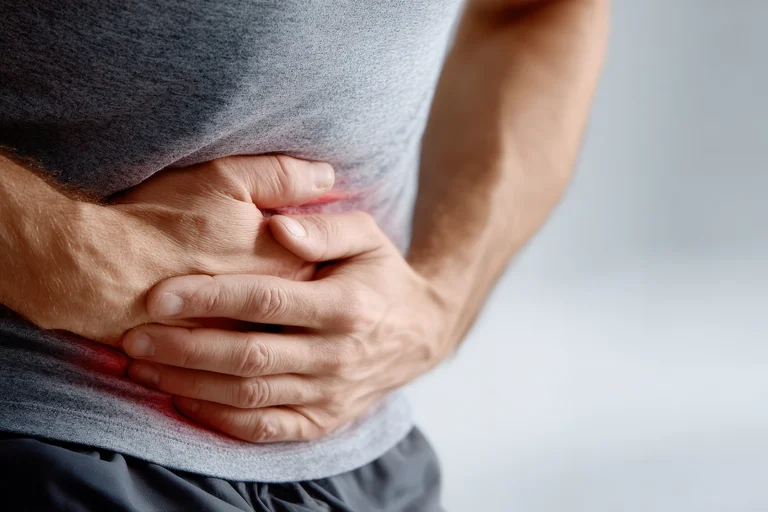 Mann hält sich den Bauch, in dem eine akute Entzündung der Bauchspeicheldrüse zu plötzlichen, anhaltenden und enormen Schmerzen führt.