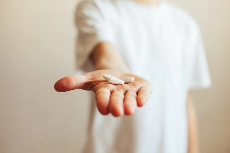 Kind hält Tabletten in der Hand, bereit sie zu nehmen.