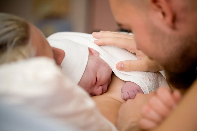 Geburt: Neugeborenes auf dem Bauch seiner Mama