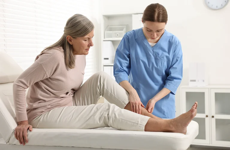 Ärztin im Gespräch mit einer Patientin über die Behandlung eines diabetischen Fußes.