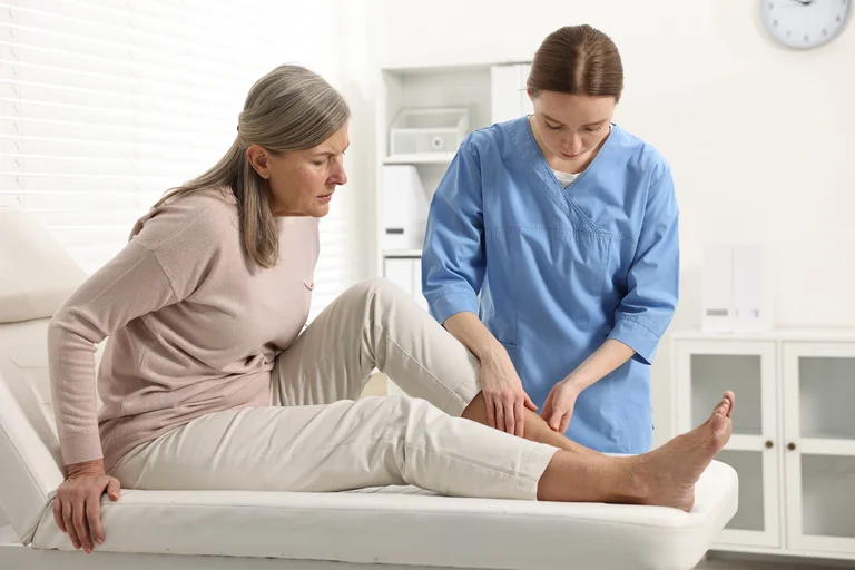Ärztin im Gespräch mit einer Patientin über die Behandlung eines diabetischen Fußes.