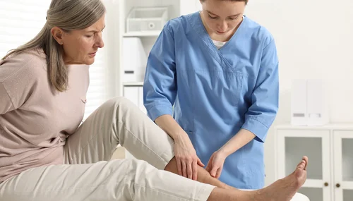 Ärztin im Gespräch mit einer Patientin über die Behandlung eines diabetischen Fußes.