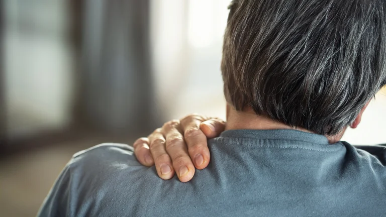 Mann mit Omarthrose hält sich die schmerzende Schulter
