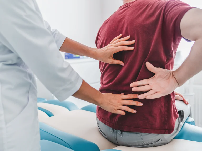Arzt untersucht Patienten mit Schmerzen im Rücken
