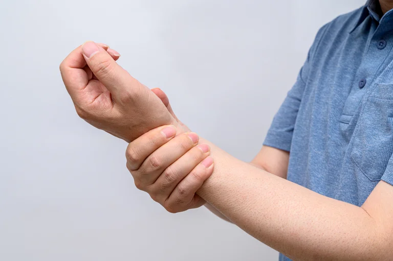 Mann mit Cubitaltunnelsyndrom hält sich das schmerzende Handgelenk