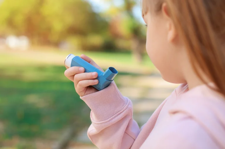 Kind benutzt einen Inhalator im Freien zur Behandlung von Atemproblemen und Asthma.