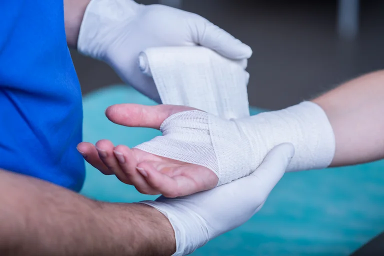 Person mit verletzter Hand wird verarztet