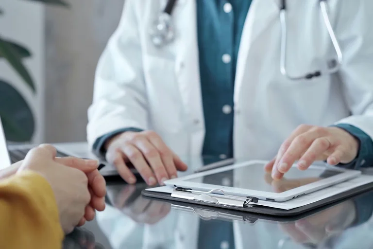 Ein Arzt berät einen Patienten zur Revisionsoperation