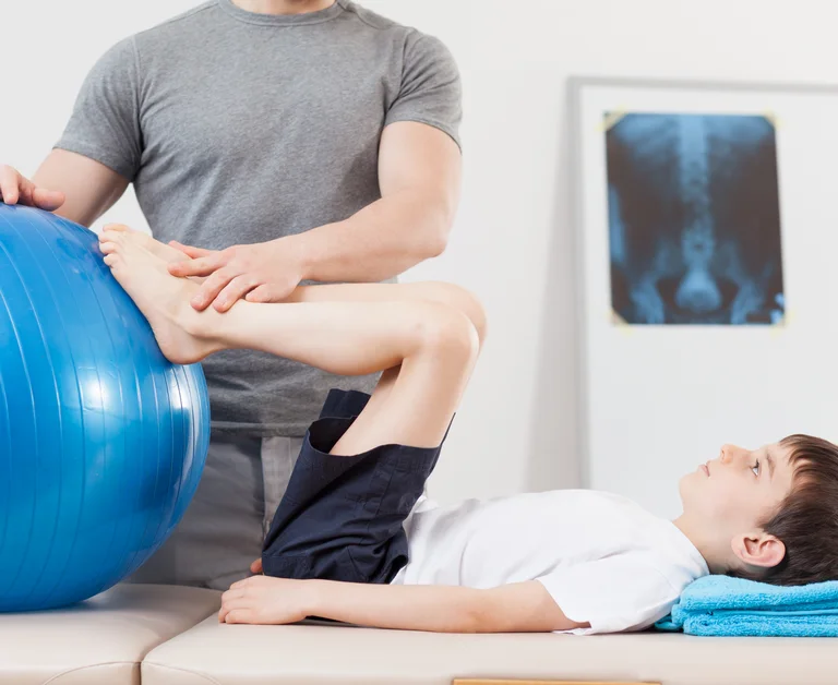Junge bekommt eine physiotherapeutische Übung gezeigt