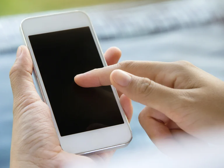 Eine Hand scrollt auf einem Smartphone