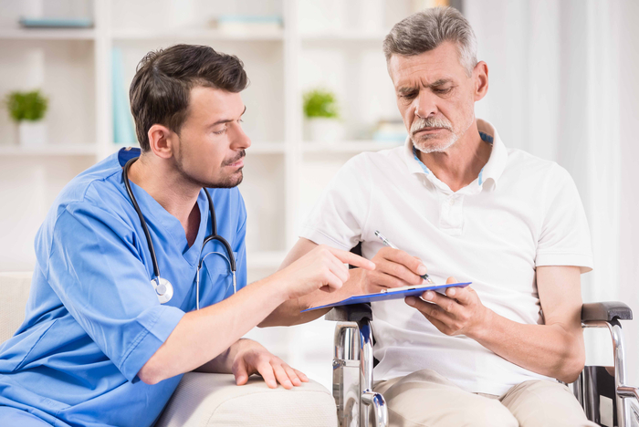 Arzt erklärt einem Patienten die Diagnose und Behandlung eines peripheren Aneurysmas anhand einer Gefäßaufnahme