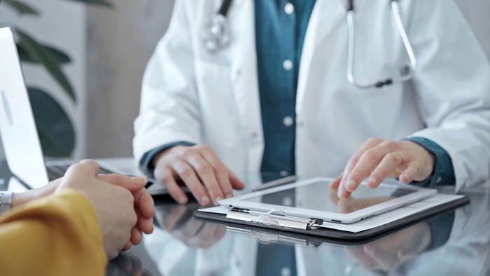 Ein Arzt berät einen Patienten zur Revisionsoperation